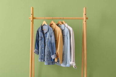 Yeşil duvarın yanında şık ceketli raflar