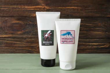 Koyu ahşap arka planda sivrisinek kovucu krem.