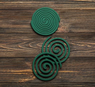 Koyu ahşap arka planda sivrisinek spiralleri