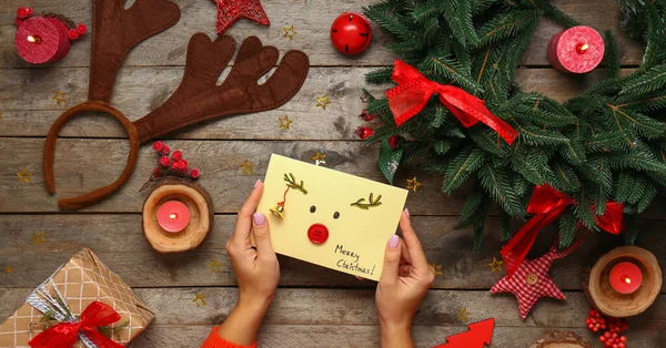 Weibliche Hände Mit Kreativer Weihnachtskarte Und Dekor Auf Holzgrund — Stockfoto