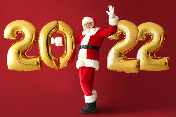 Санта Клаус и воздушные шары в форме фигуры 2022 на красном фоне