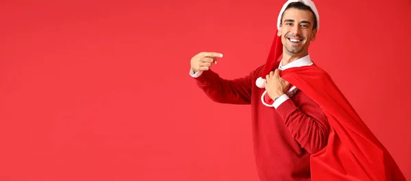 Young Man Santa Hat Holding Bag Full Gifts Red Background — Stock Photo, Image