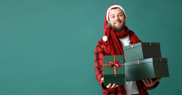 戴着圣诞礼帽的快乐男人拿着绿色背景的圣诞礼品盒 上面有文字的空间 — 图库照片