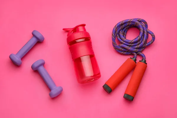 粉红背景下的铃铛 跳绳和水瓶 — 图库照片