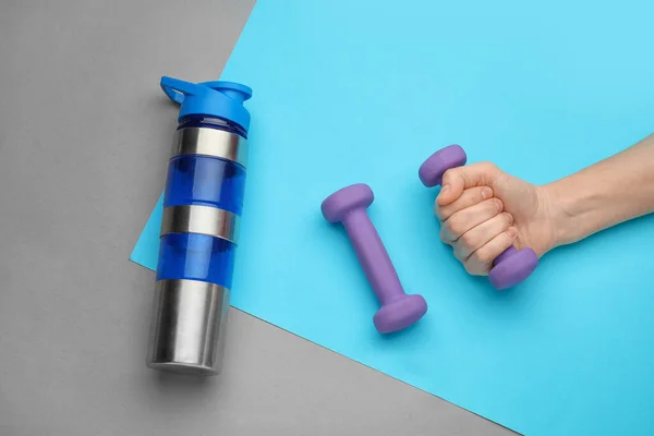 Female Hand Dumbbells Bottle Color Background — Stock Photo, Image