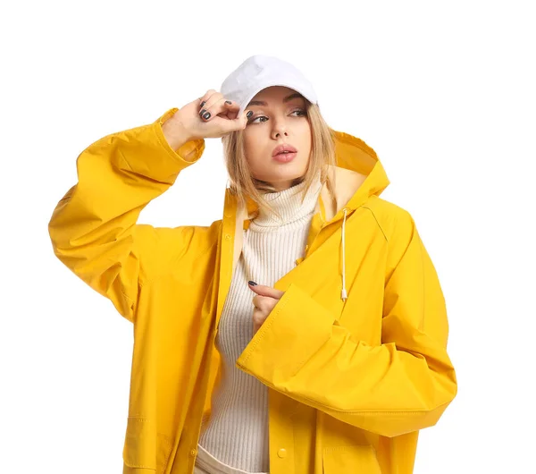 若いです女性で黄色のコートと野球帽上の白い背景 — ストック写真