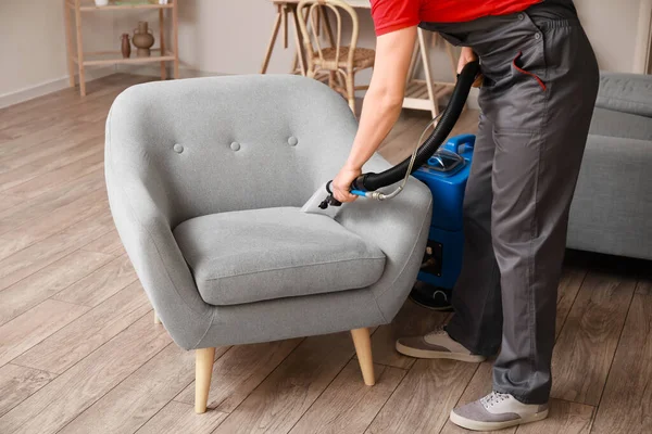 Male Worker Removing Dirt Grey Armchair Vacuum Cleaner Room — Stock Photo, Image