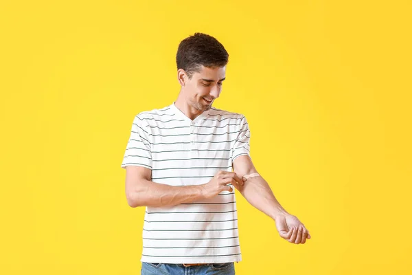 Jongeman Aanbrengen Van Gips Zijn Arm Gele Achtergrond — Stockfoto