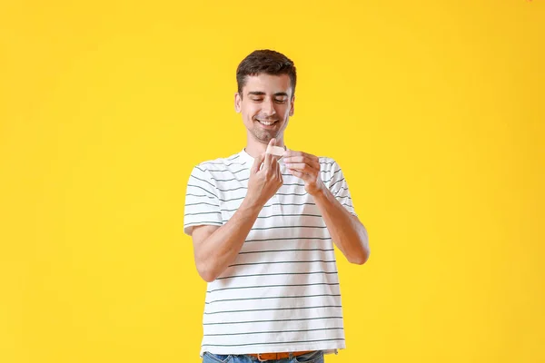 Young Man Applying Plaster His Finger Yellow Background — Stock Photo, Image