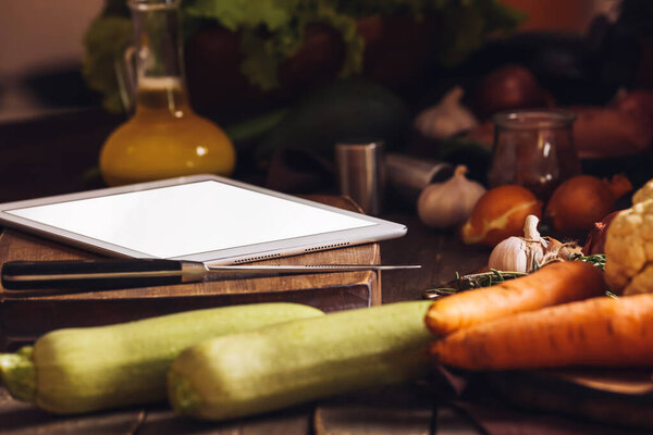 Tablet computer with knife on board in kitchen, closeup