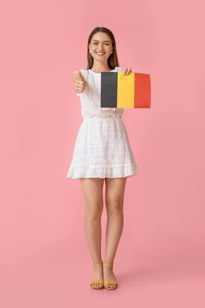 ベルギーの国旗を背景に親指を立てる若い女性 — ストック写真