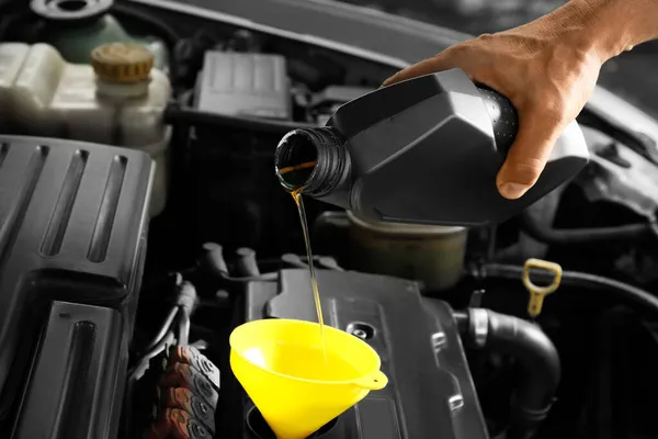 男性机械师将机油从罐体倒入汽车发动机 — 图库照片