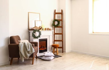 Noel için dekore edilmiş modern şömine ve koltuk.