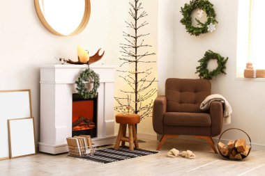 Noel için dekore edilmiş modern şömine ve koltuk.
