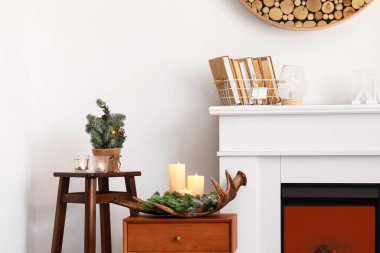 Mumlu masalar ve şöminenin yanındaki köknar dalları.