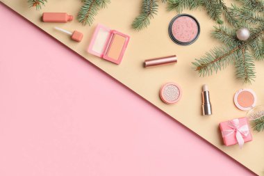 Bej ve pembe arka planda Noel dekoru olan makyaj malzemeleri