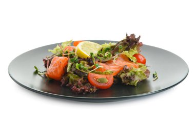 Beyaz arka planda somon ve limonlu lezzetli salata.