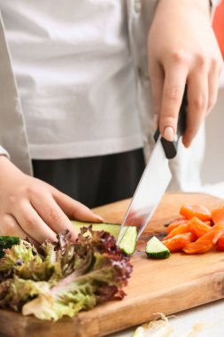 Masada taze sebze doğrayan kadın, yakın plan.