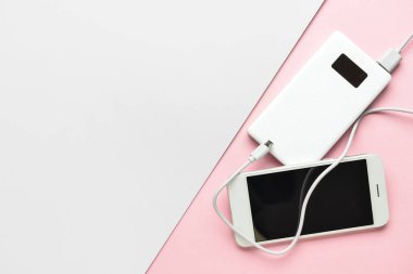 Renkli arkaplanda yeni güç bankası ve cep telefonu