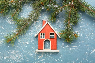 Grunge arka planında köknar dalları olan bir ev figürü. Kış konsepti