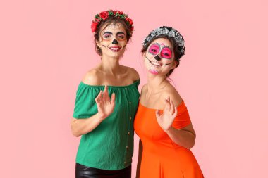 Renkli arka planda boyalı kafatası olan şık kadınlar. Meksika Ölüler Günü 'nün Kutlaması (El Dia de Muertos)
