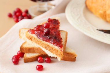 Yaban mersini reçelli lezzetli tostlar ve bej ahşap arka planda taze böğürtlen