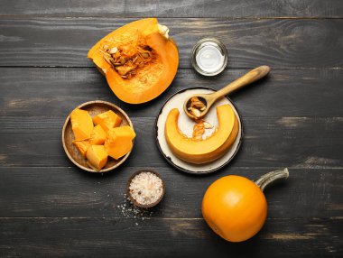 Kesik balkabağı, deniz tuzu ve koyu ahşap arka planda yağlı kompozisyon