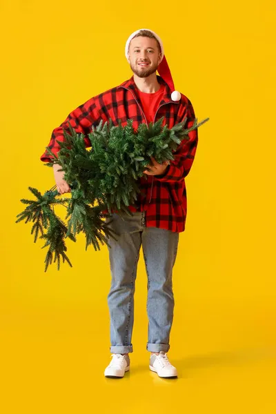 Fiatal Férfi Télapó Kalap Karácsonyfa Sárga Háttér — Stock Fotó