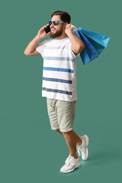 Kara Cuma Alışveriş Çantalı Mutlu Genç Adam Yeşil Arka Planda — Stok fotoğraf