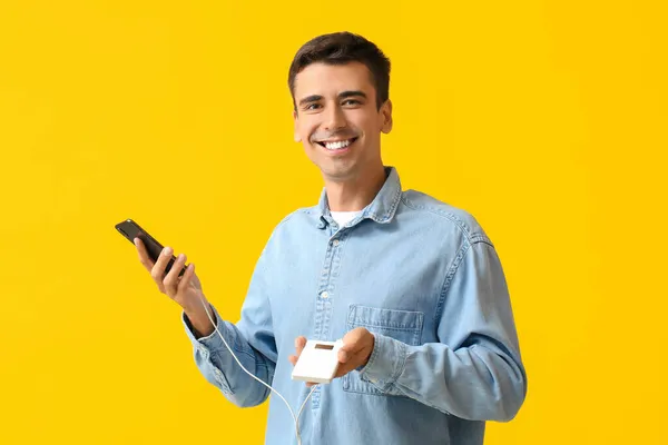 Young Man Phone Power Bank Color Background — Stock Photo, Image