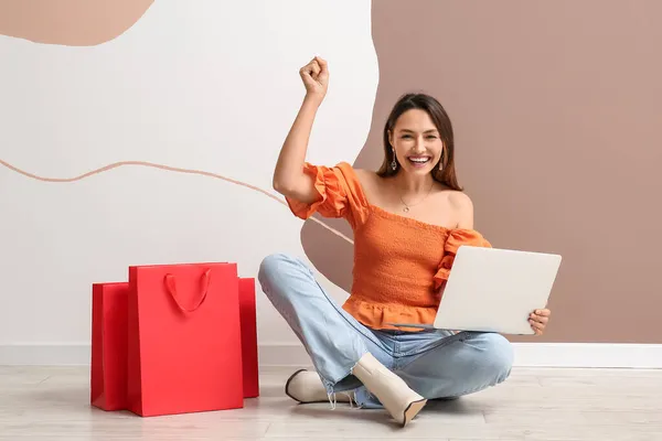 Mujer Joven Feliz Con Ordenador Portátil Bolsas Compras Fondo Color — Foto de Stock