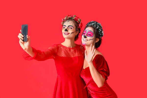 Stijlvolle Vrouwen Met Geschilderde Schedel Gezichten Nemen Selfie Tegen Kleur — Stockfoto