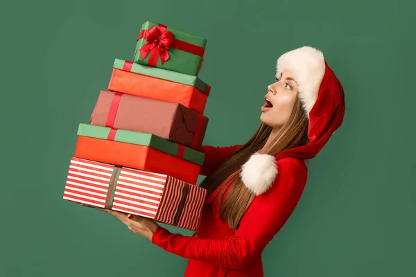 Surprised Young Woman Santa Hat Christmas Presents Green Background — Stock Photo, Image