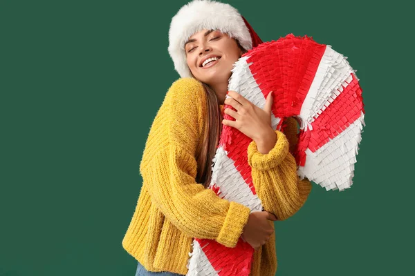 Hübsche Junge Frau Mit Weihnachtsmütze Und Zuckerrohr Pinata Auf Grünem — Stockfoto