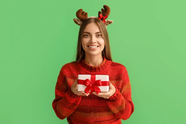年轻美丽的鹿角女子 背景是绿色的圣诞礼物 — 图库照片