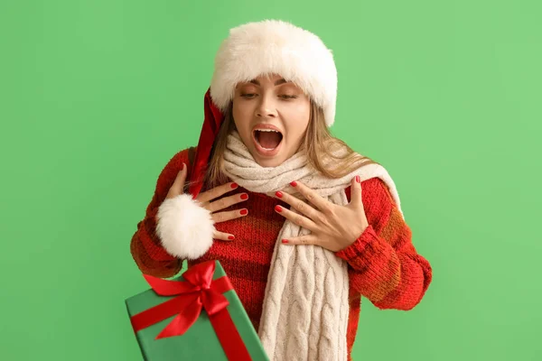 Surprised Young Woman Santa Hat Receiving Christmas Gift Green Background — Stock Photo, Image