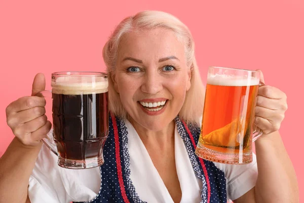 愛らしいですオクトーバーフェスト女性保持マグカップとともにビールオンピンクの背景 — ストック写真