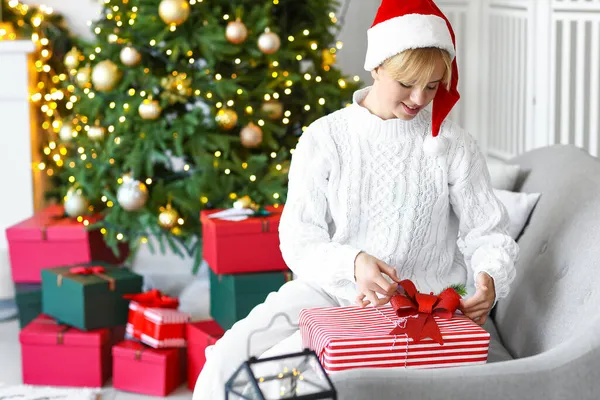 Schöne Junge Frau Mit Weihnachtsmütze Und Weihnachtsgeschenk Hause — Stockfoto