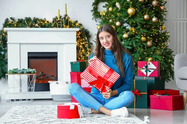 美しいです若いです女性とともにクリスマスプレゼントに家 — ストック写真