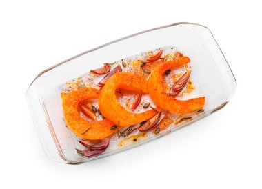 Beyaz arka planda lezzetli fırında balkabağı parçaları olan bir tabak.