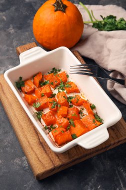 Siyah arka planda lezzetli kavrulmuş balkabağı ile pişirme tabağı