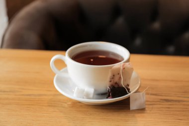 Kafede çay poşeti ve şekerli bir fincan, yakın plan.