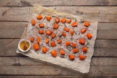 Ahşap zemin üzerinde lezzetli kavrulmuş balkabağı parçaları olan parşömen.