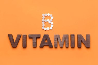 Kelime VITAMIN ve B harfi renk arkaplanındaki haplardan yapılmıştır