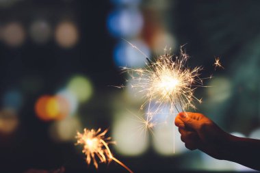 Gece vakti yanan bir Noel maytaplı kadın eli