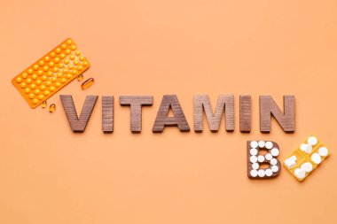 Renk arkaplanında haplar olan VITAMIN B metni