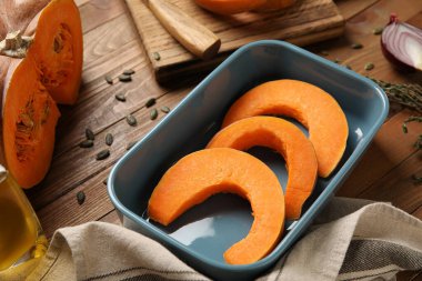 Ahşap zemin üzerinde balkabağı parçaları olan fırın tabağı.