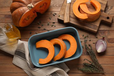 Ahşap zemin üzerinde balkabağı parçaları olan fırın tabağı.