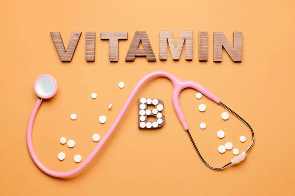 Texto Vitamina Com Estetoscópio Pílulas Sobre Fundo Cor — Fotografia de Stock