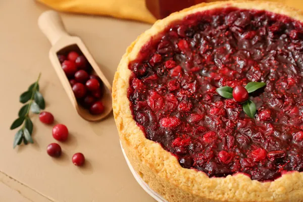 Renkli ahşap arka planda lezzetli yaban mersinli turta, yakın plan.